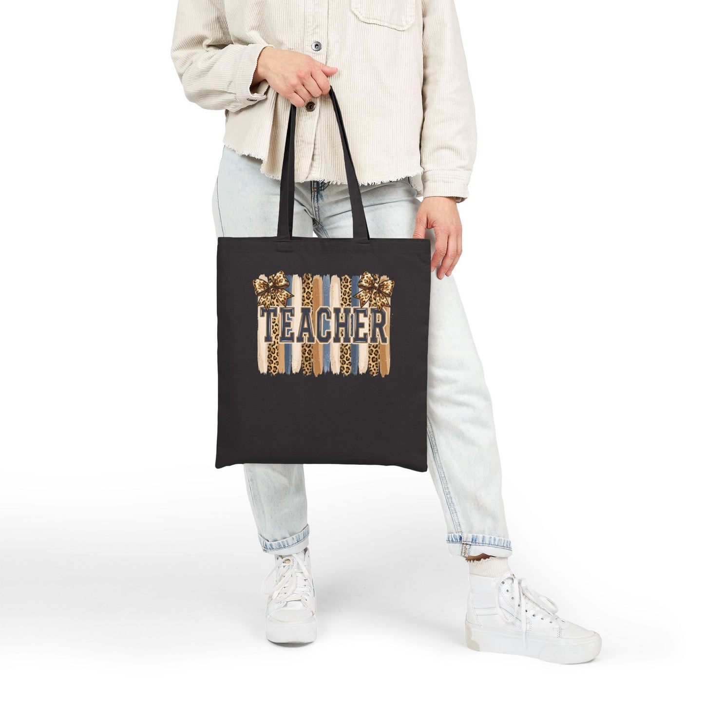 Black canvas tote bag with leopard “Teacher” graphic, held by straps