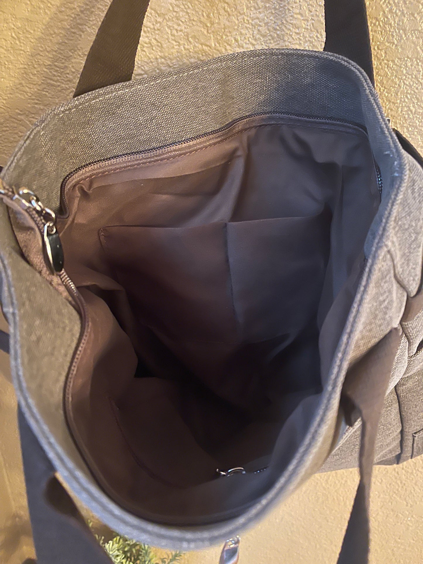 Gray canvas bookbag interior with zip closure and lined inner pocket