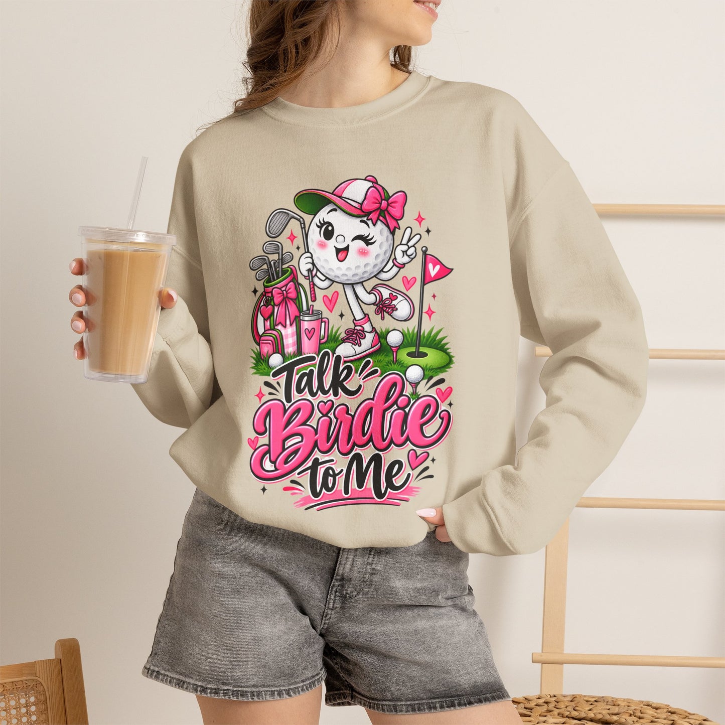 Light beige crewneck sweatshirt on model with golf cat character graphic and pink floral hearts