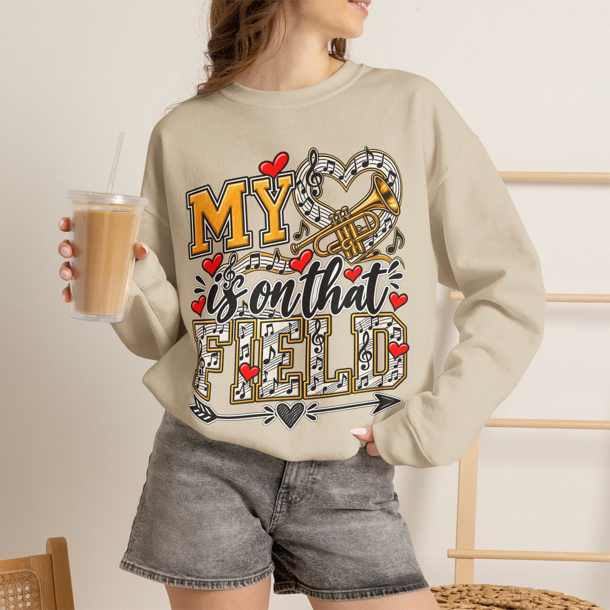 Sand sweatshirt worn by model; heart and trumpet marching-band graphic