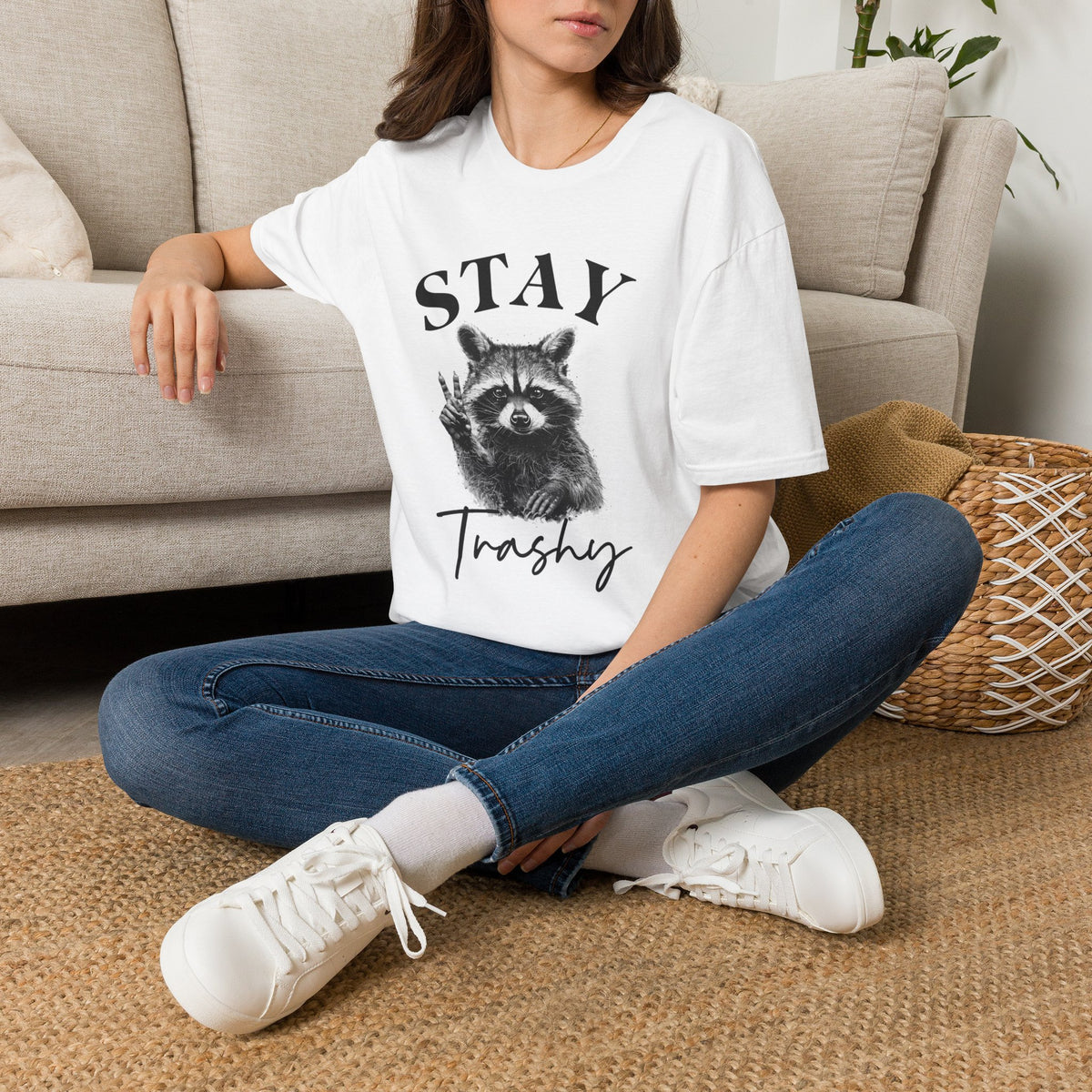 White T-shirt worn by model featuring raccoon “STAY” and “Trashy” front graphic