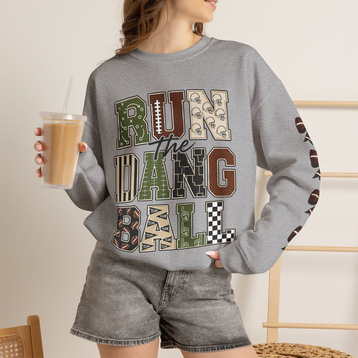 Sport grey crewneck sweatshirt, front graphic patch lettering and football mask bow accents