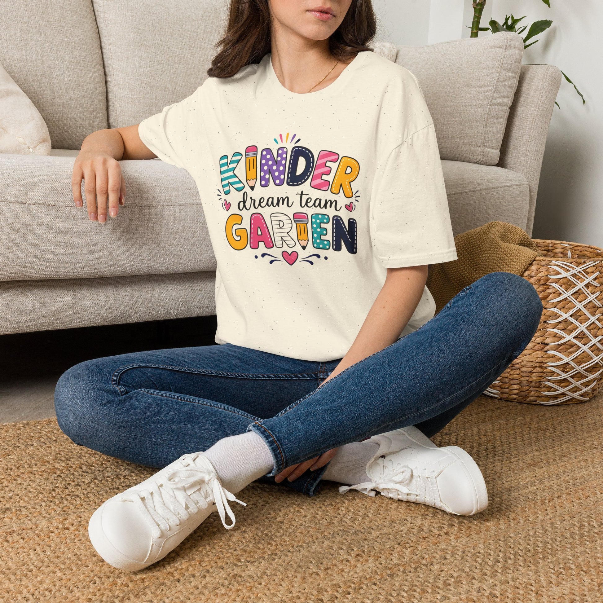 Natural/off-white crew-neck T-shirt with colorful “Kinder Dream Team Garden” graphic.