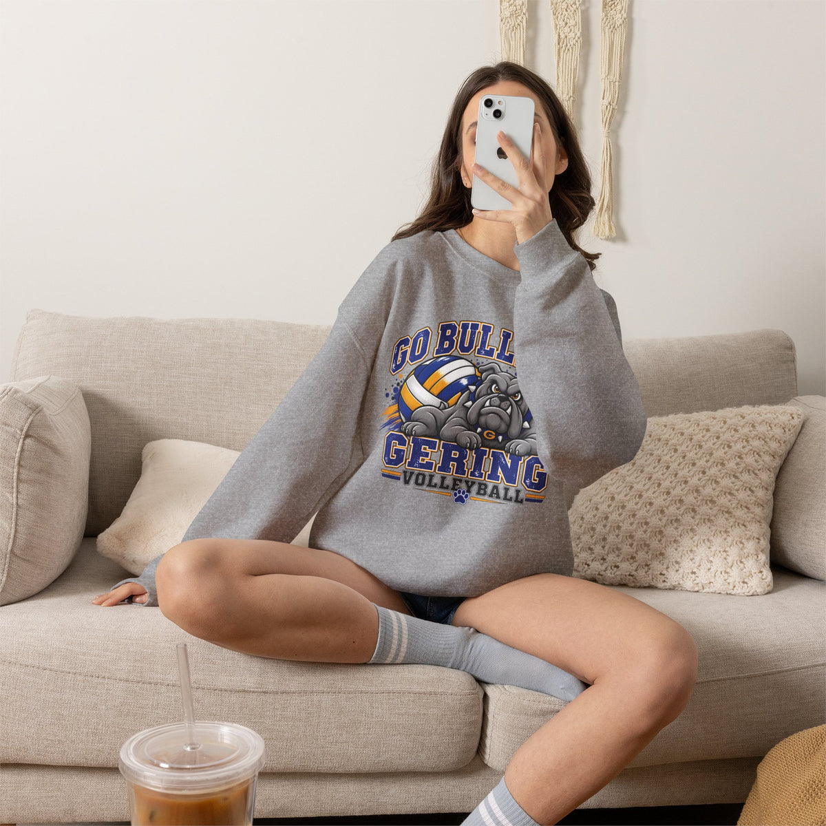 Sport grey crewneck sweatshirt worn by seated model, with bulldog and volleyball team graphic