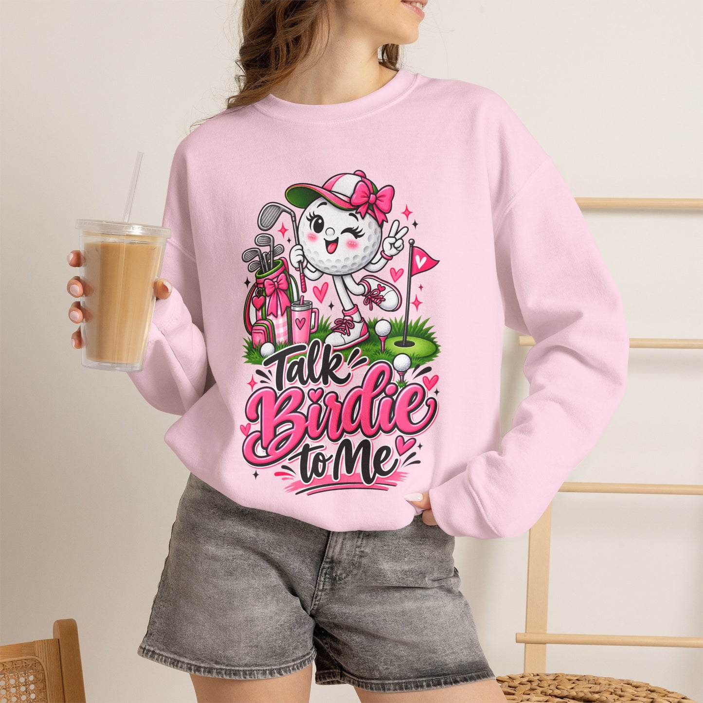 Pink crewneck sweatshirt featuring golf-ball character graphic on chest