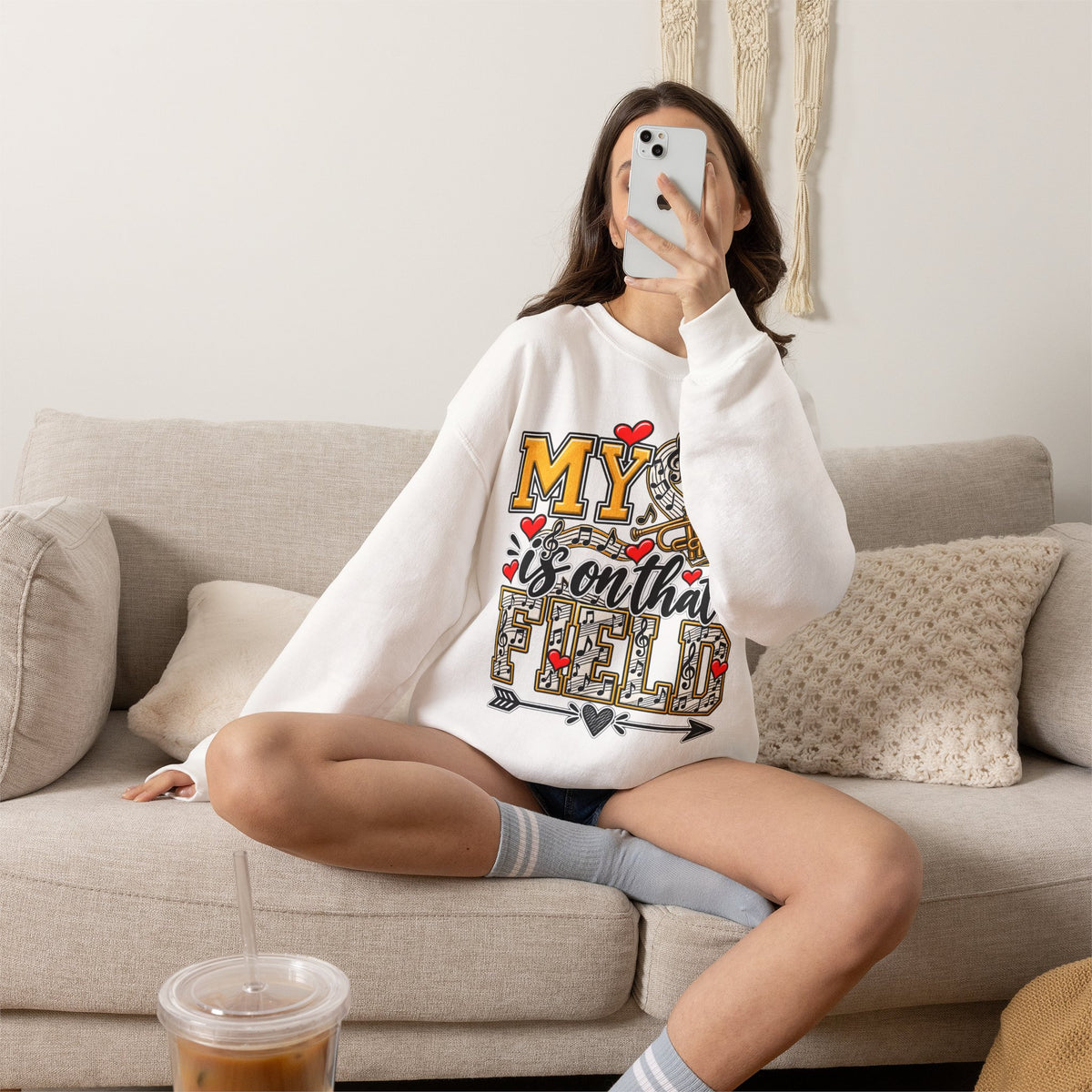 White sweatshirt worn by model; heart and trumpet marching-band graphic