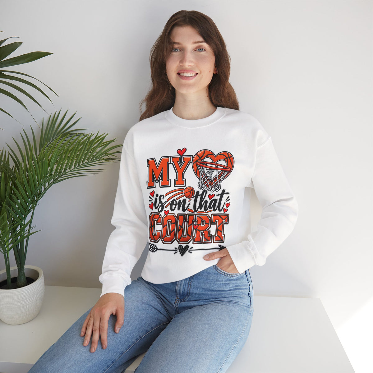 White crewneck sweatshirt with basketball heart graphic, styled with blue jeans