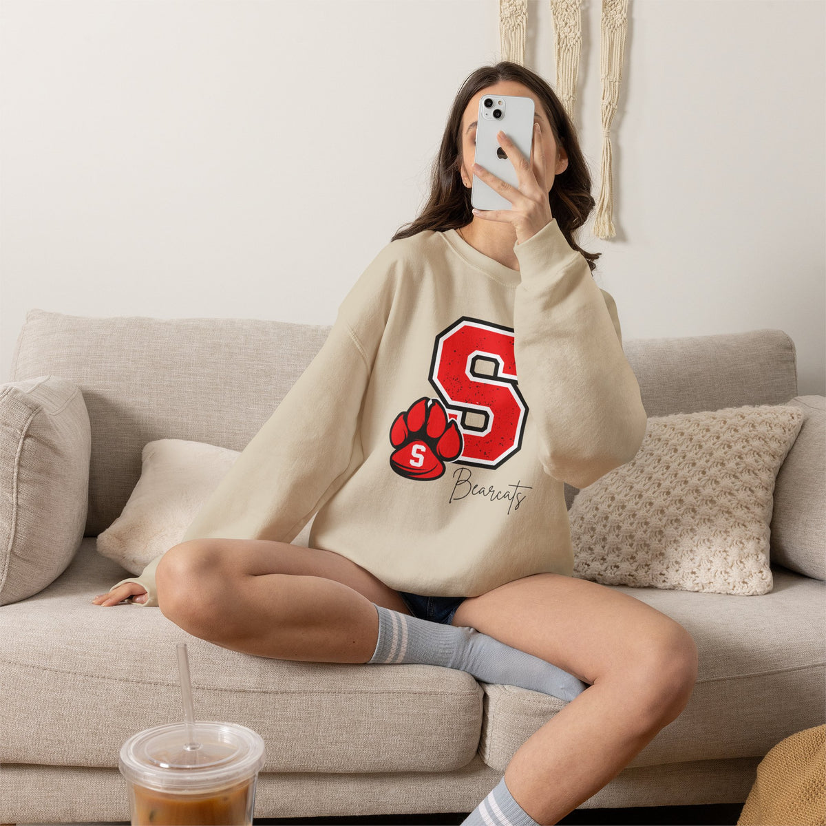 Sand crewneck sweatshirt with red S paw graphic, worn with denim shorts