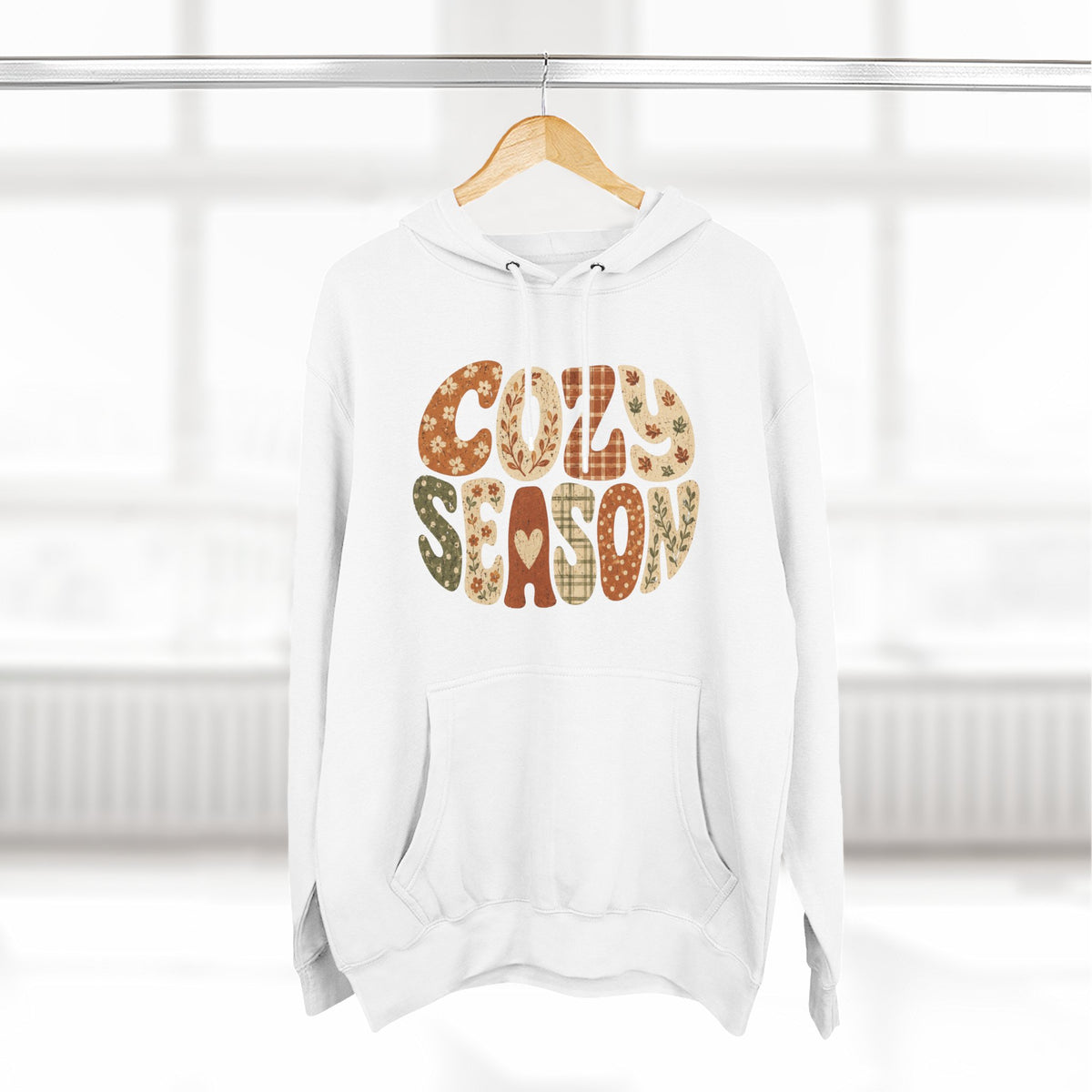 White fleece pullover hoodie with “COZY SEASON” leopard-style graphic, front view