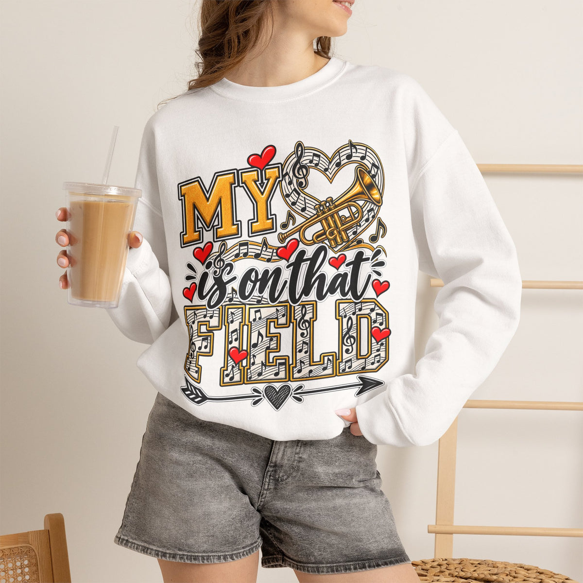 White sweatshirt worn by model; heart and trumpet marching-band graphic