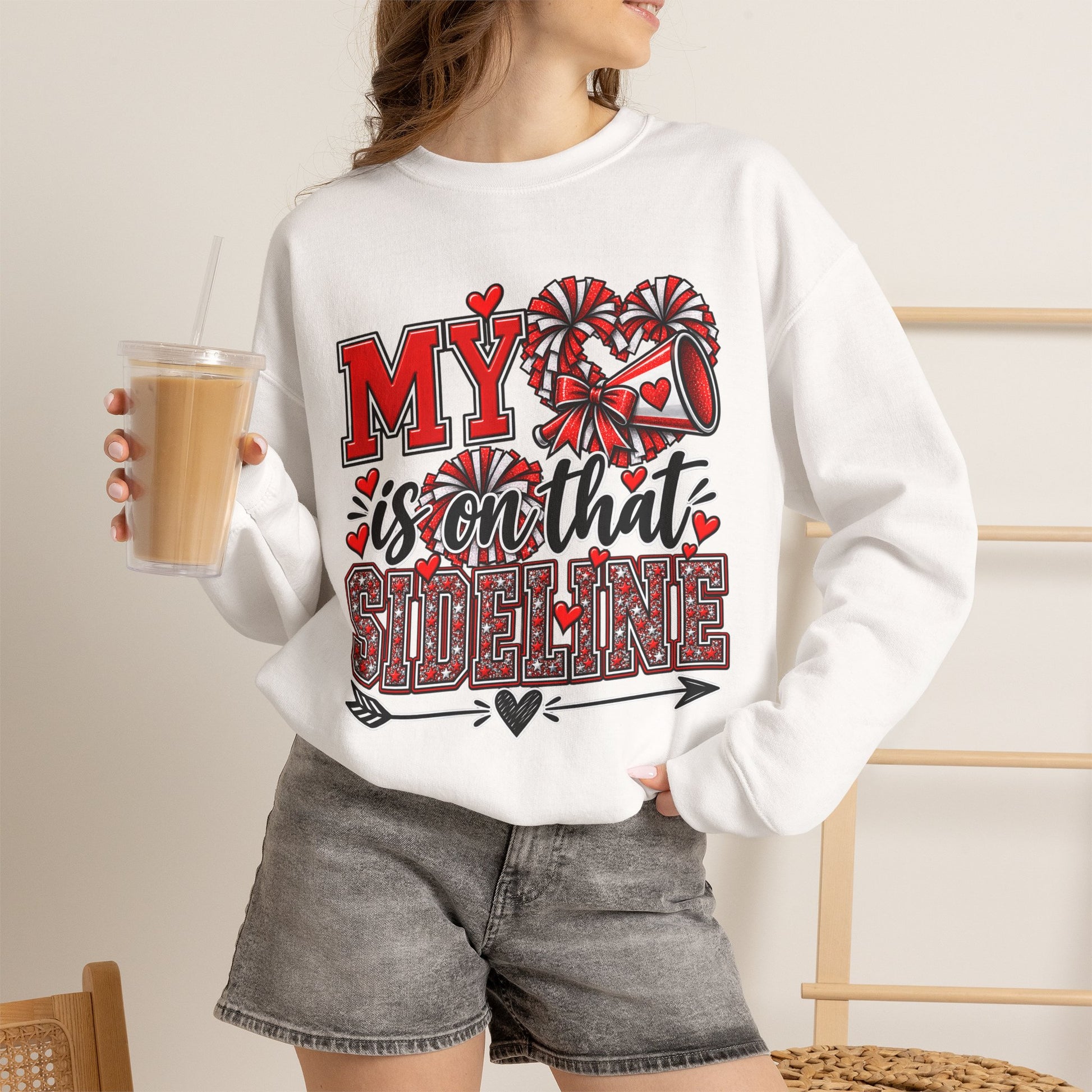 White crewneck sweatshirt on model with red heart sideline graphic, long sleeves