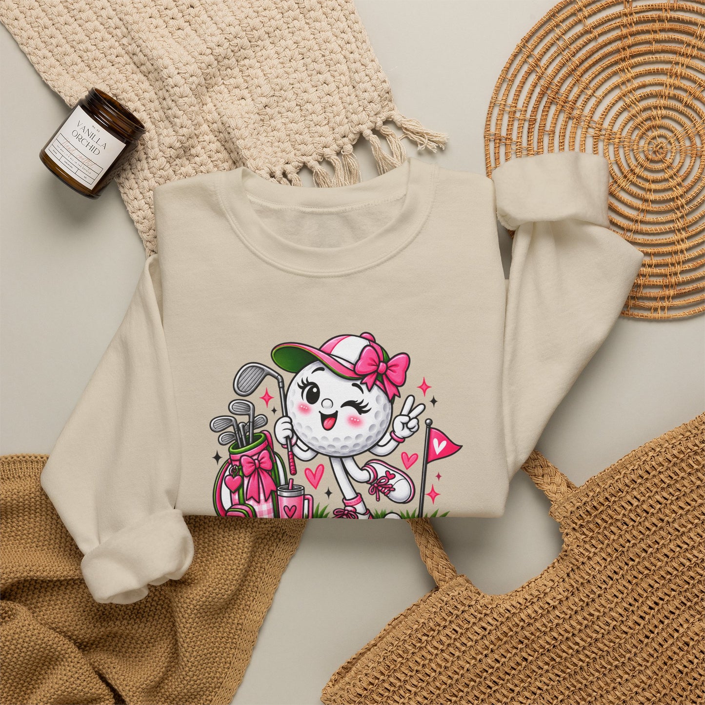Off-white sweatshirt flat lay with golf cat character graphic and pink floral hearts