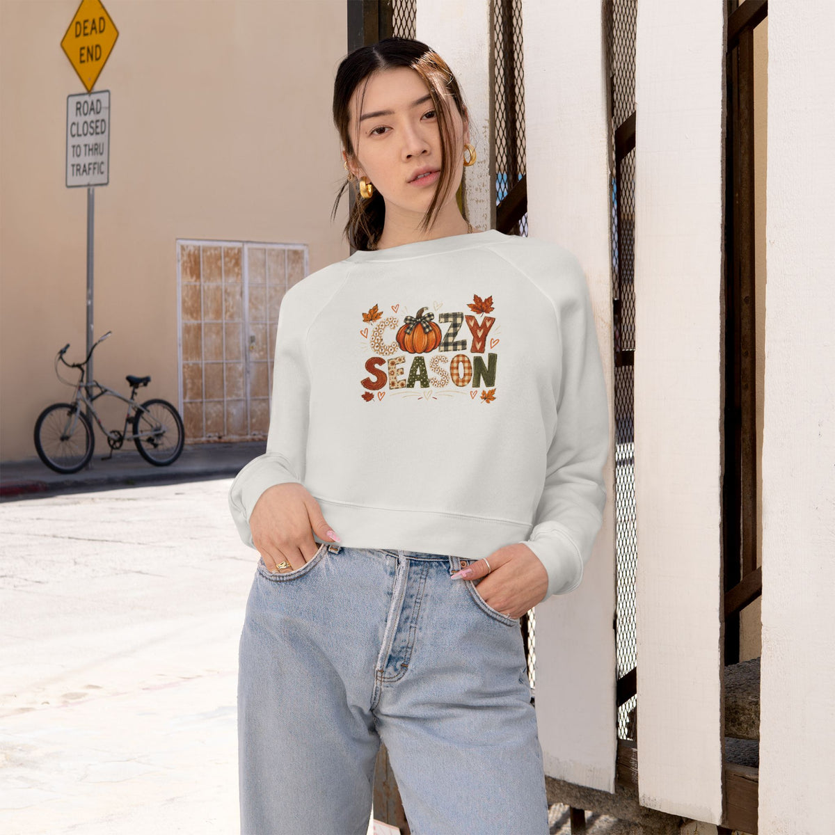 Women's cropped white sweatshirt worn on model with 'Season' graphic