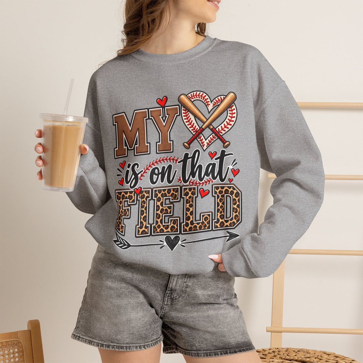 Sport grey crewneck sweatshirt with baseball heart and crossed bats front graphic, worn