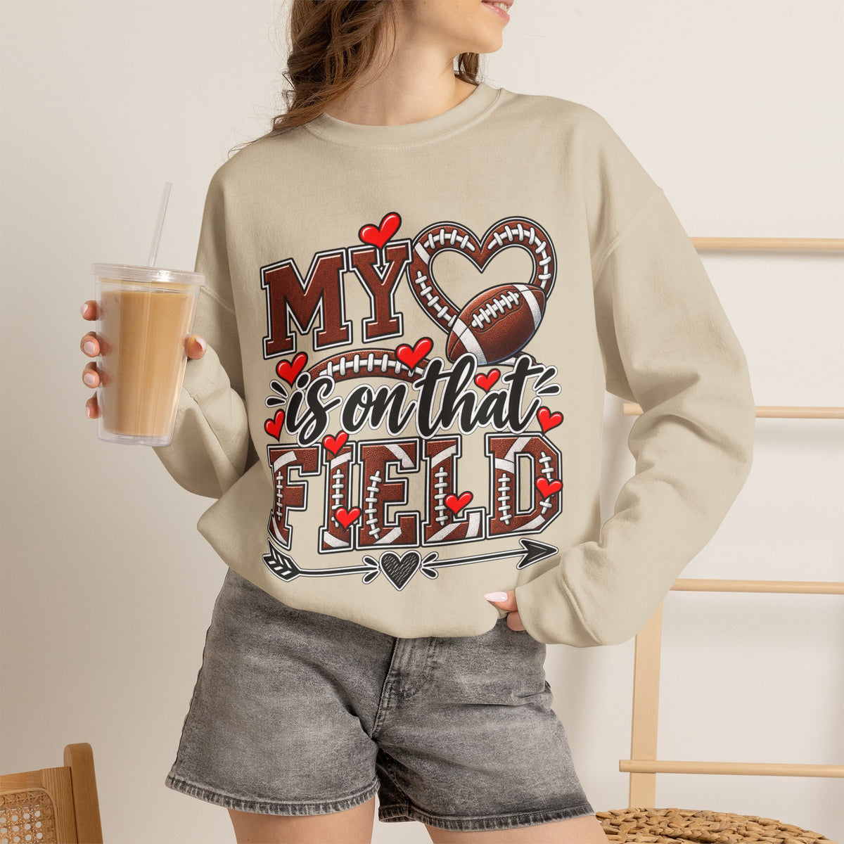 Sand crewneck sweatshirt on model with 'My' heart and football graphic
