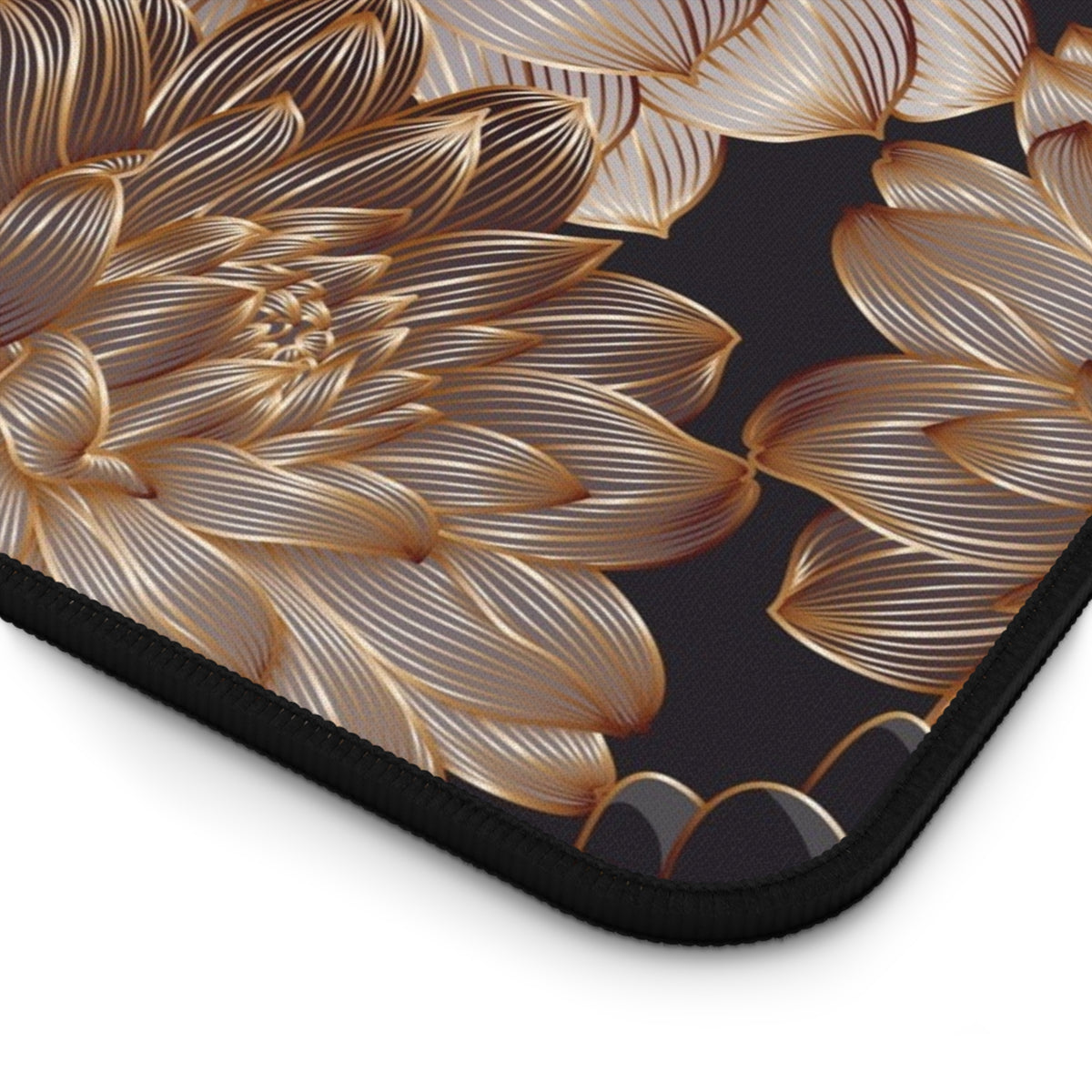 Close-up of gold floral pattern on dark desk mat with stitched corner