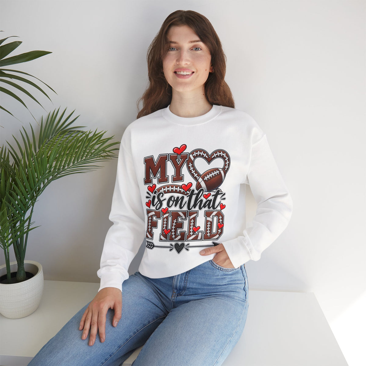 White crewneck sweatshirt on model with 'My' heart and football graphic