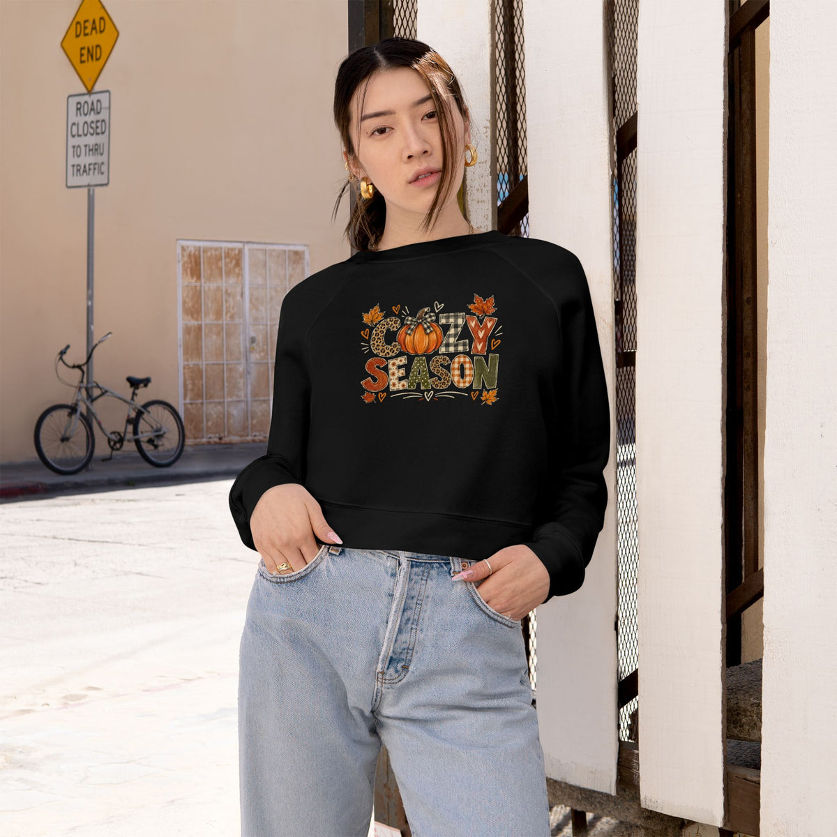 Women's cropped black sweatshirt worn on model with 'Season' graphic