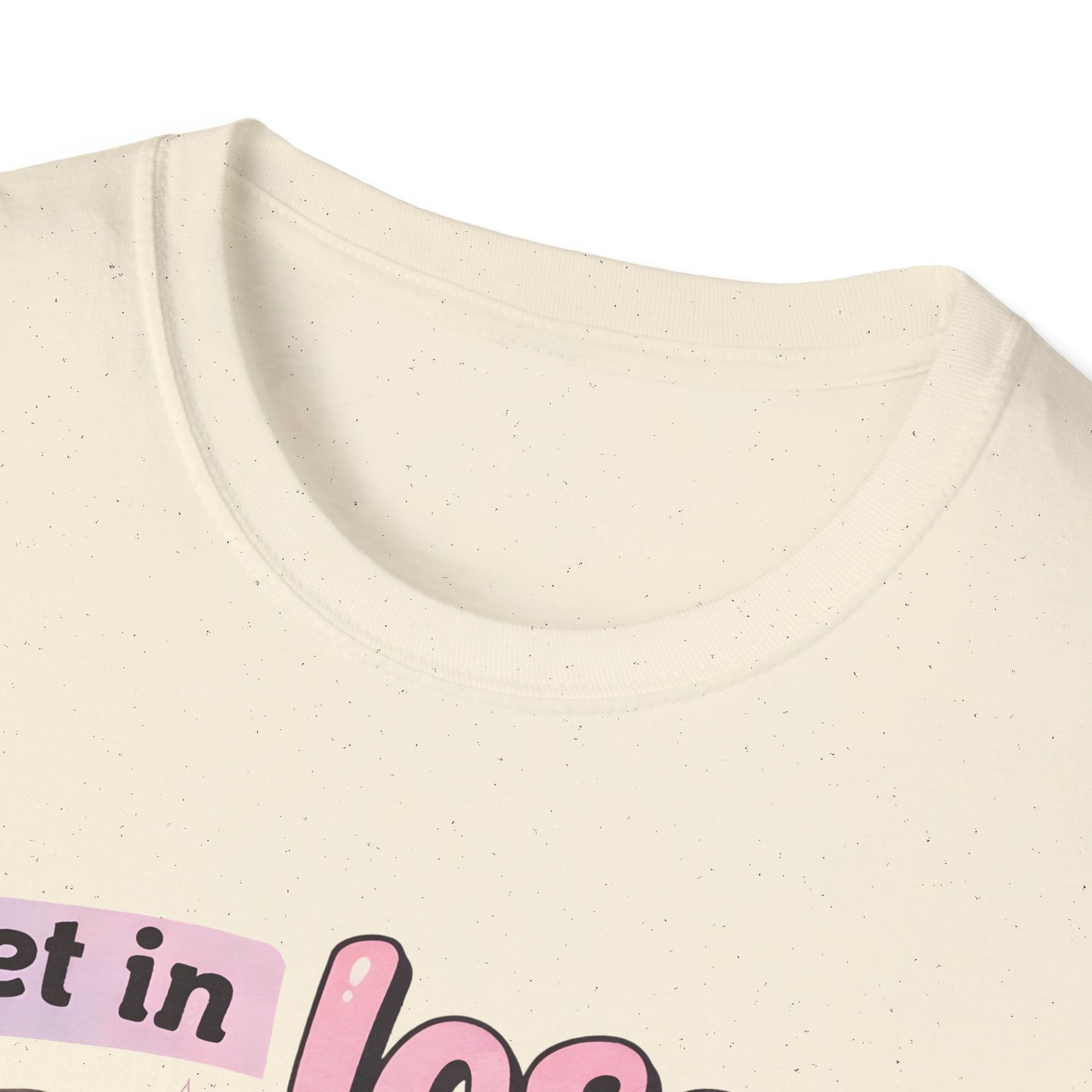 Cream T-shirt neckline close-up with partial pink golf cart graphic