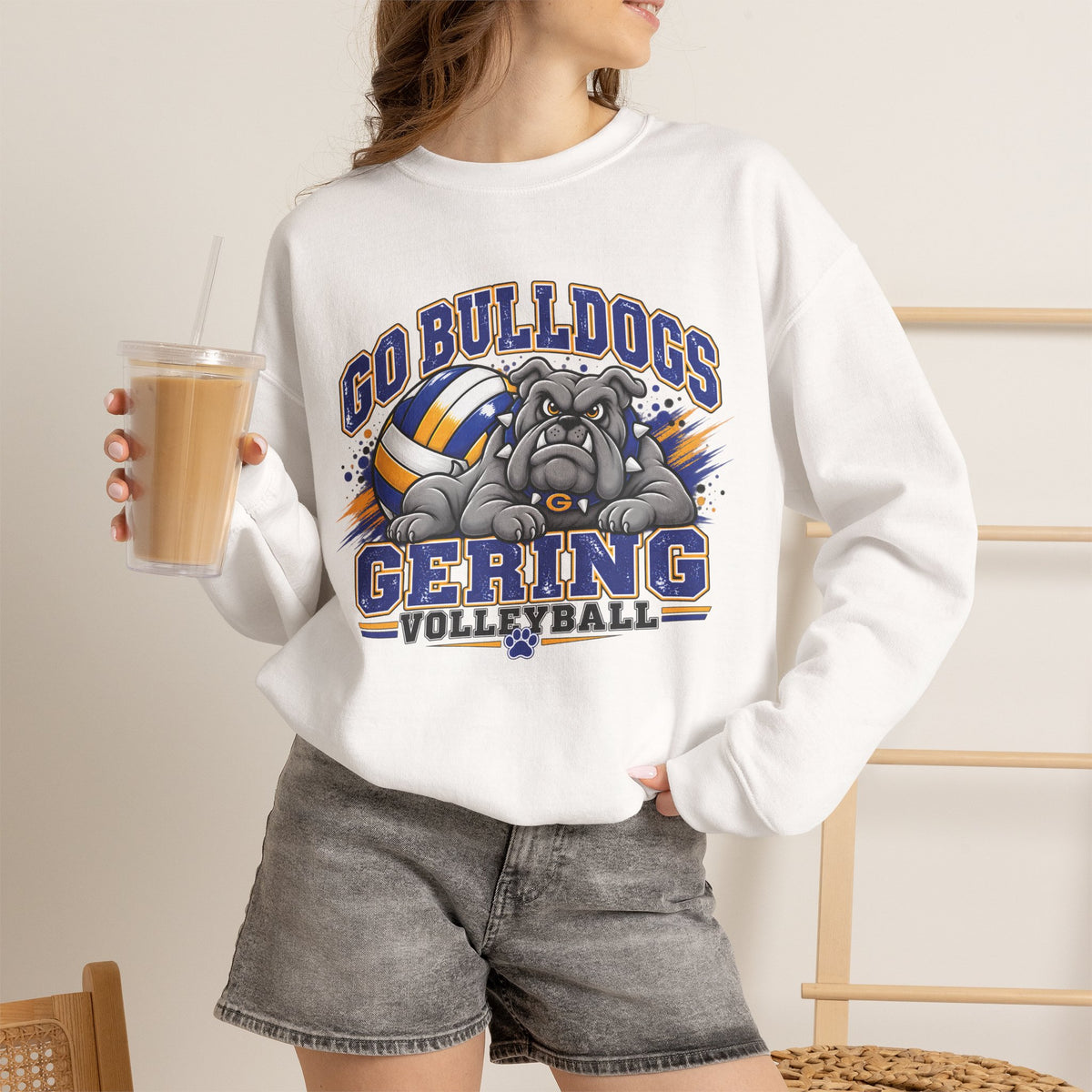 White crewneck sweatshirt worn by model, featuring a bulldog and volleyball team graphic