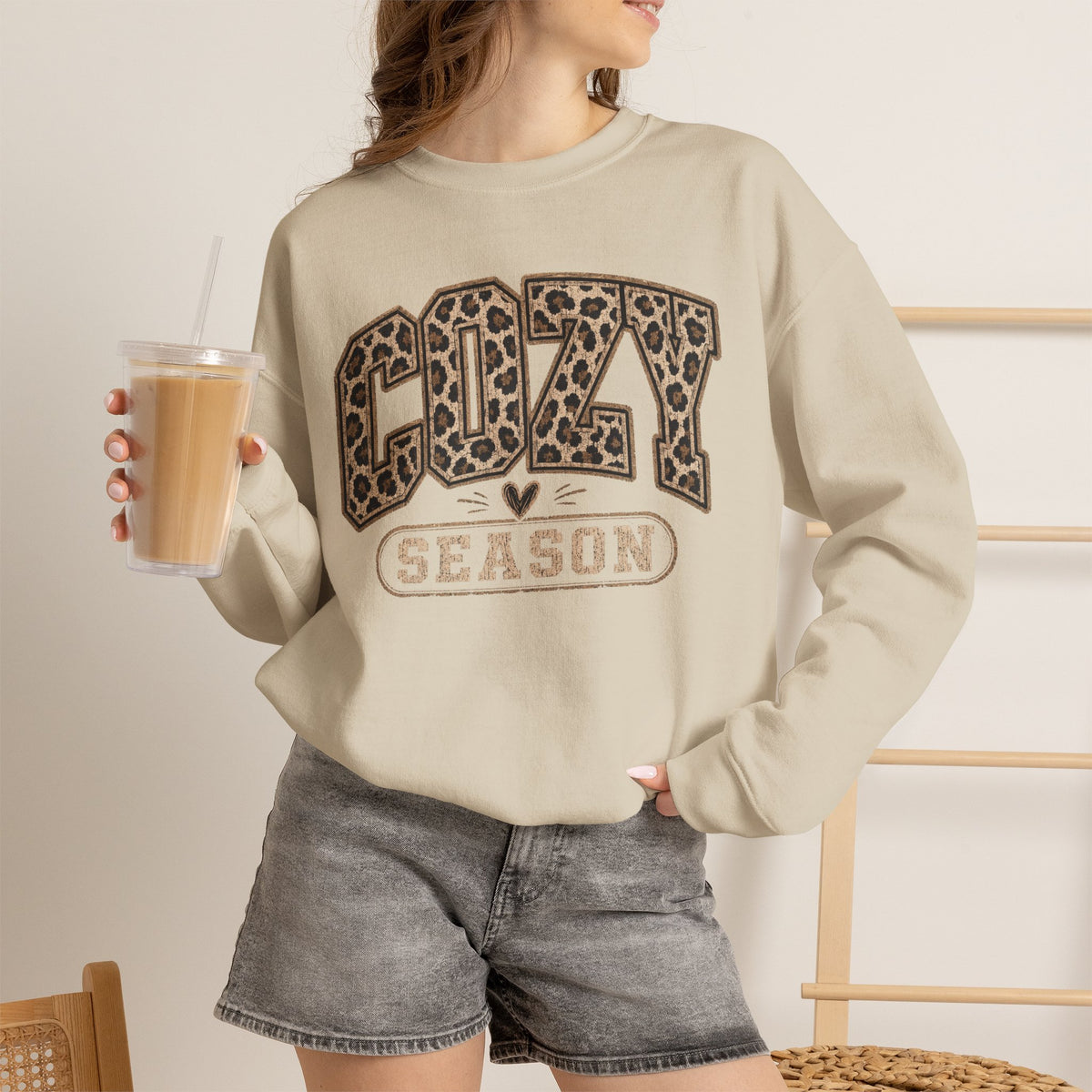 Cream leopard-print crewneck sweatshirt with “COZY SEASON” graphic and long sleeves