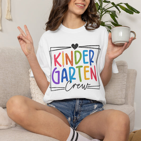 White crew t-shirt with colorful “Kinder Garten” graphic and small heart above text