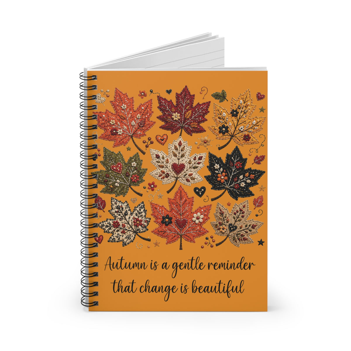 Orange autumn leaf spiral notebook with quote cover, showing stacked lined pages