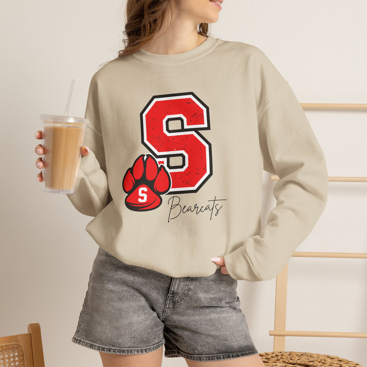 Sand crewneck sweatshirt with red S paw graphic, worn with denim shorts