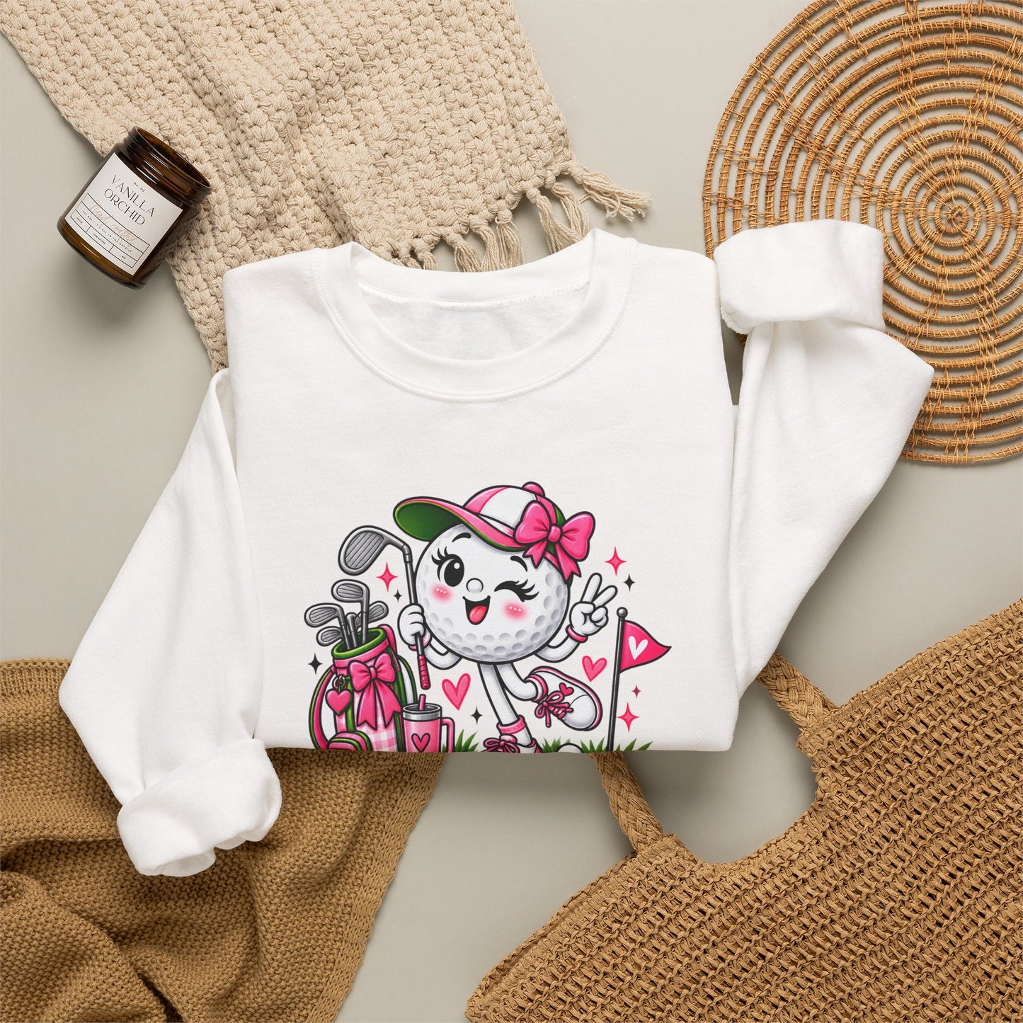 Off-white sweatshirt, flat lay, with golf cat character graphic and pink floral hearts