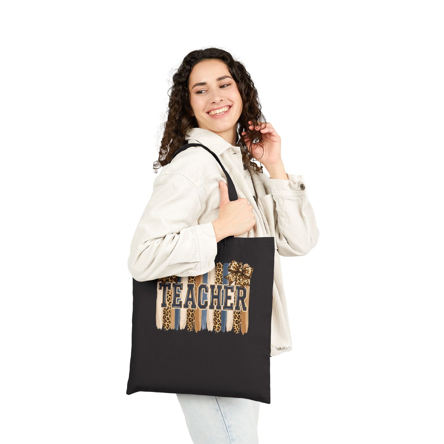 Black canvas tote bag with leopard “Teacher” graphic, carried by person