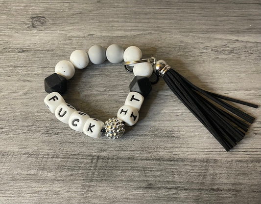 Beaded silicone keychain wristlet with black and white letter beads, tassel, and charm