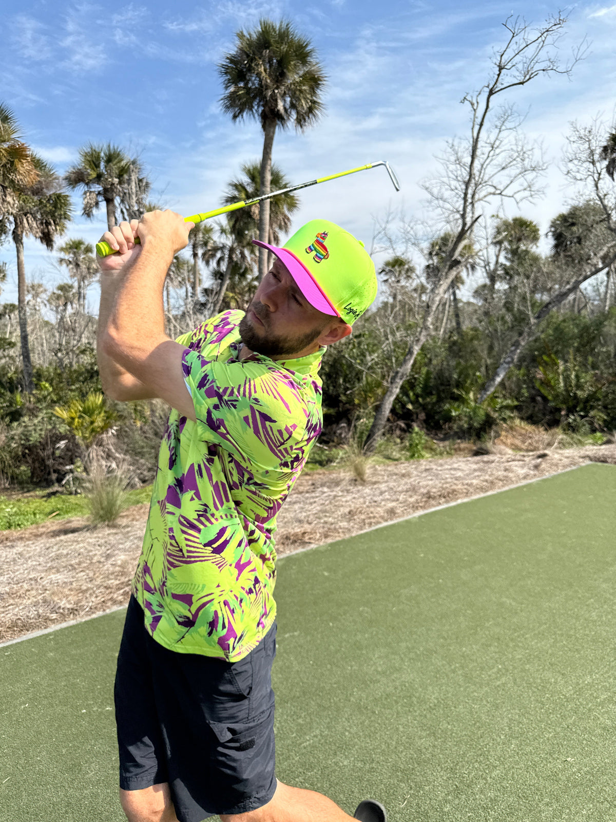 Snapback golf cap worn on the course, neon green crown with purple brim