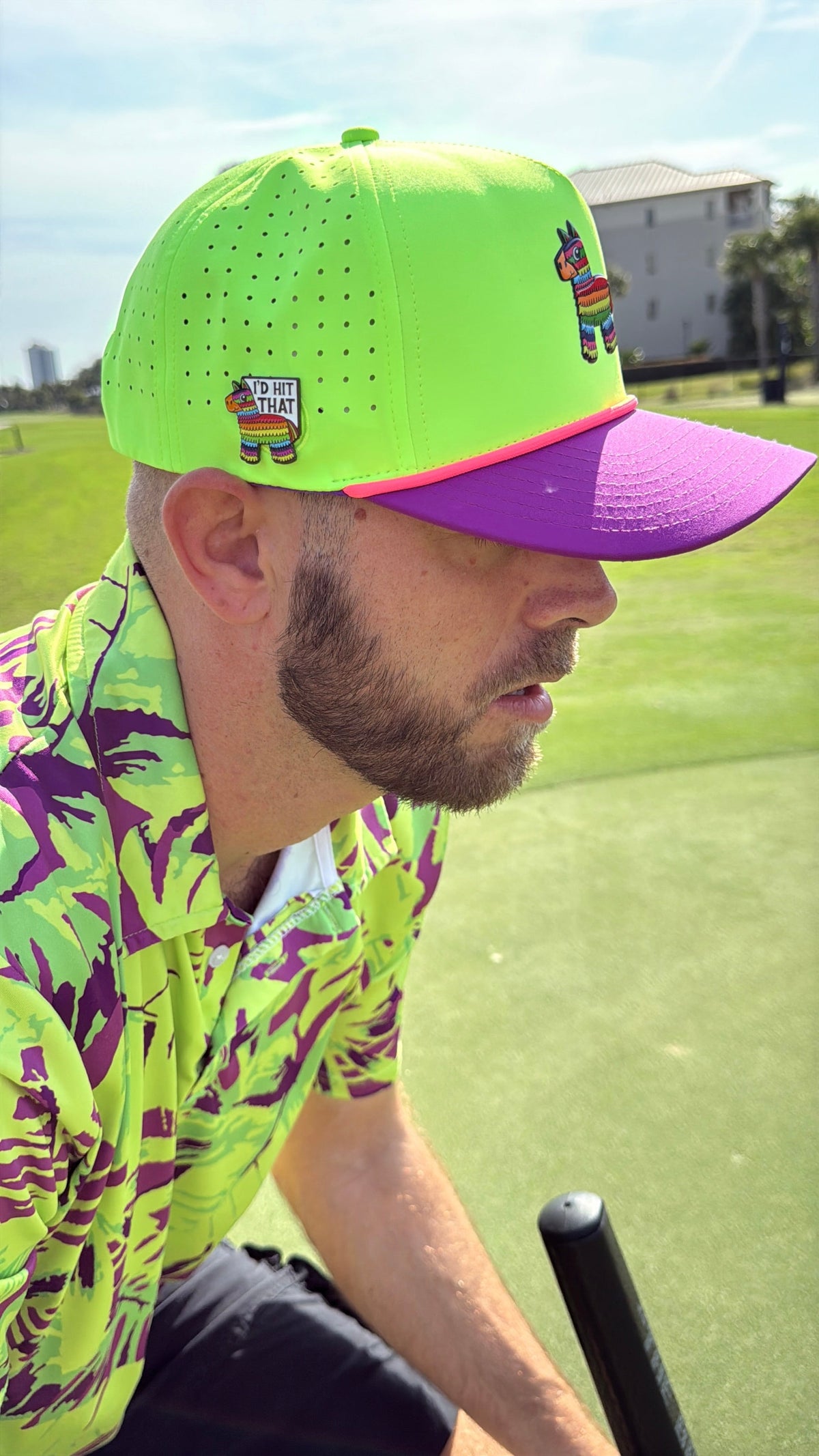 Snapback golf cap worn by a golfer, neon green crown with purple brim