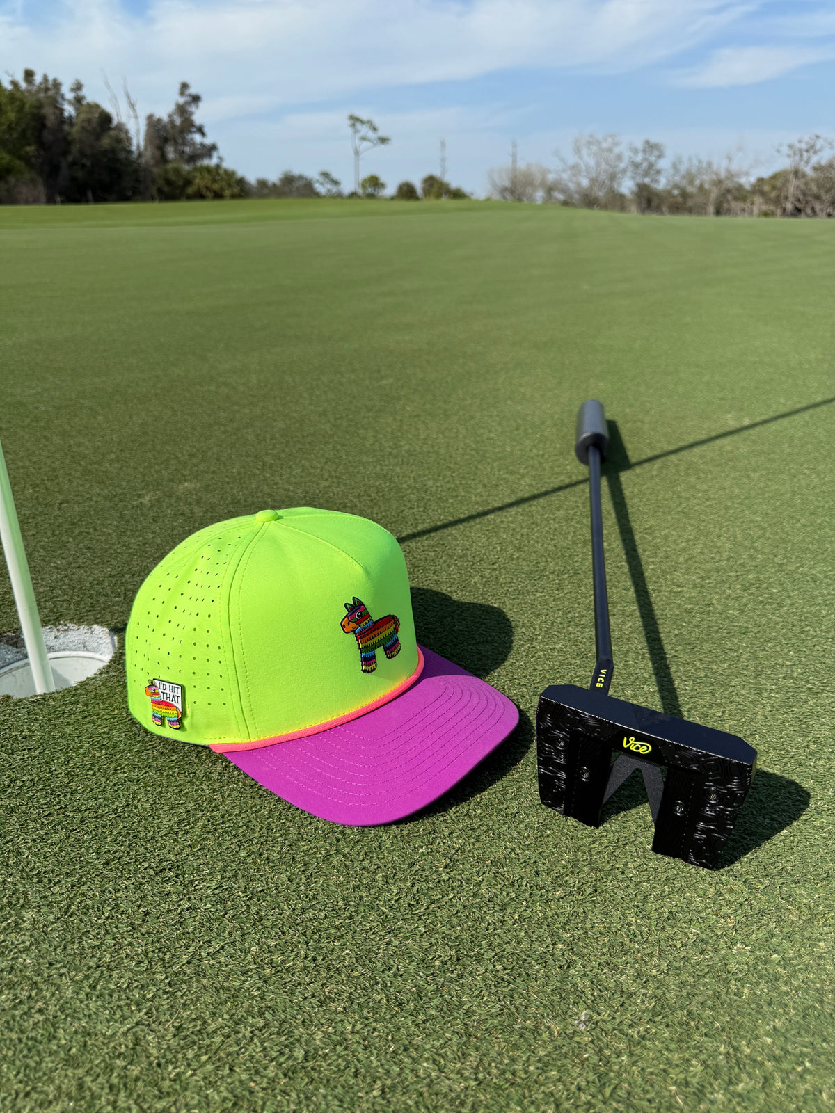 Snapback golf cap on a golf course, neon green crown with purple brim