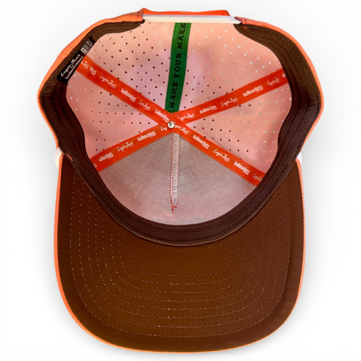 Inside view of orange golf snapback hat with brown underside and stitched panels