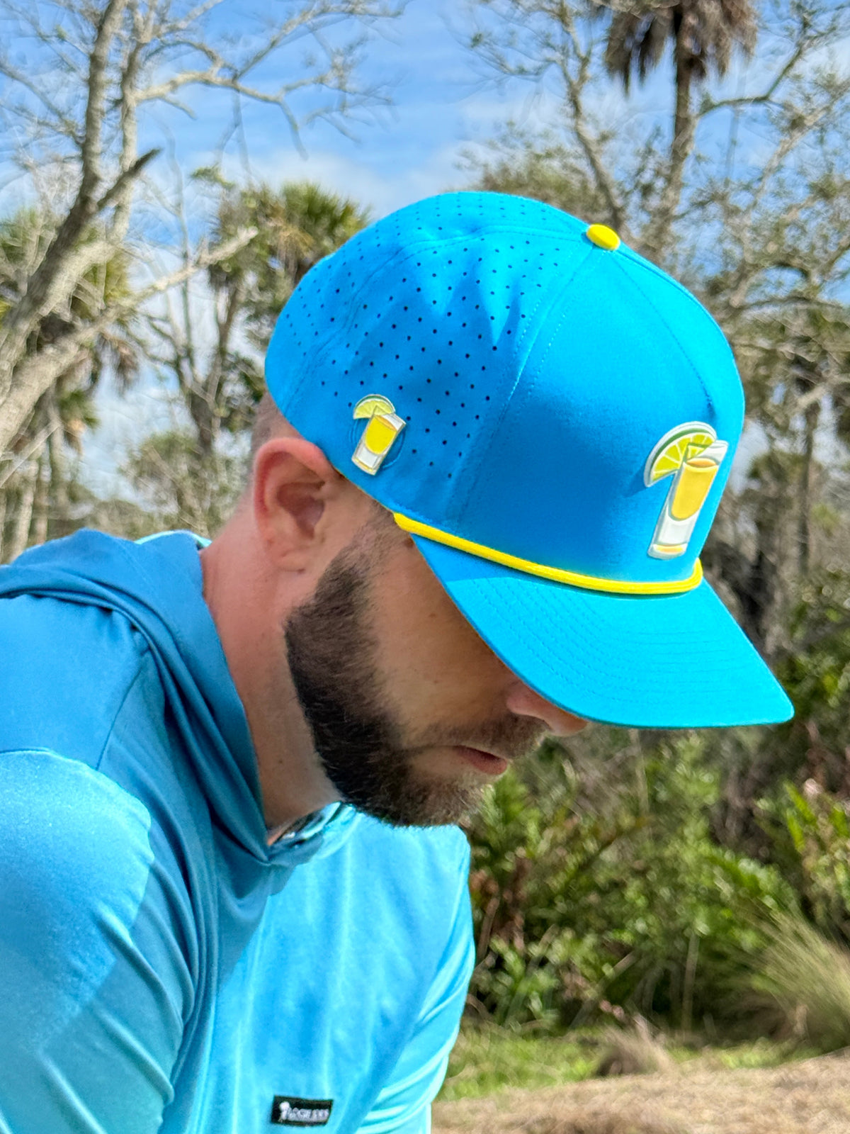 Blue snapback golf cap with yellow trim and tequila-lime front ball marker holder.