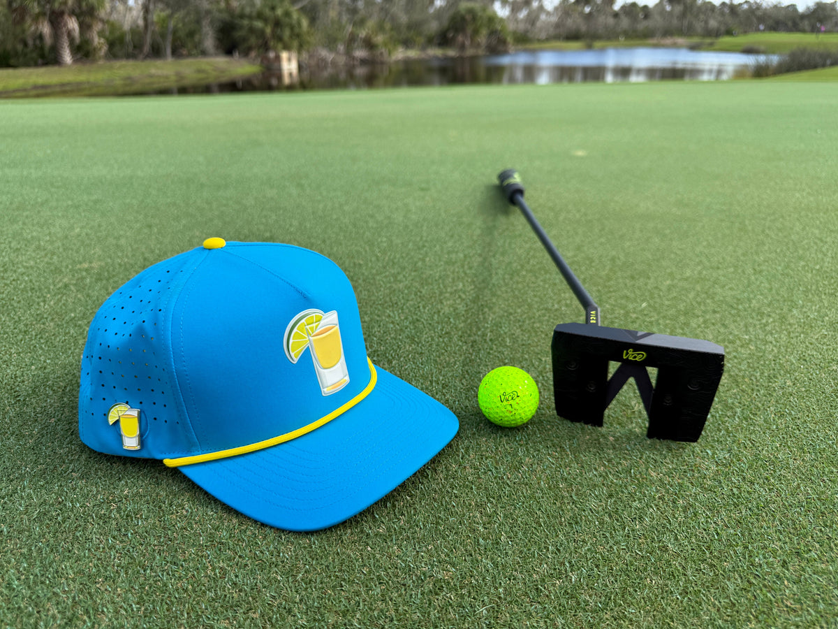 Blue snapback golf cap with yellow trim and tequila-lime magnetic ball marker holder.