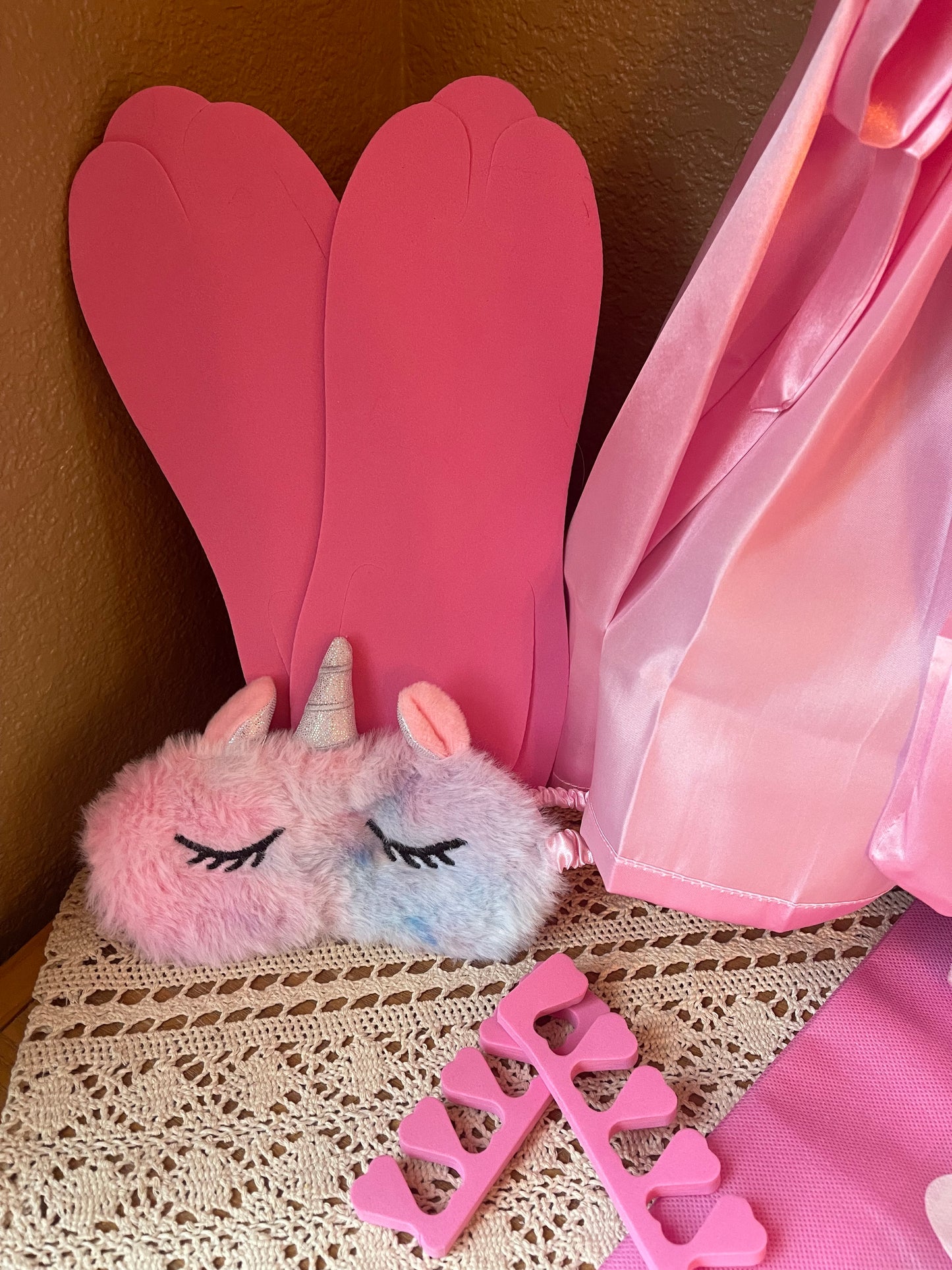 Pink plush paw slippers and foam letter pieces with pink satin robe drape