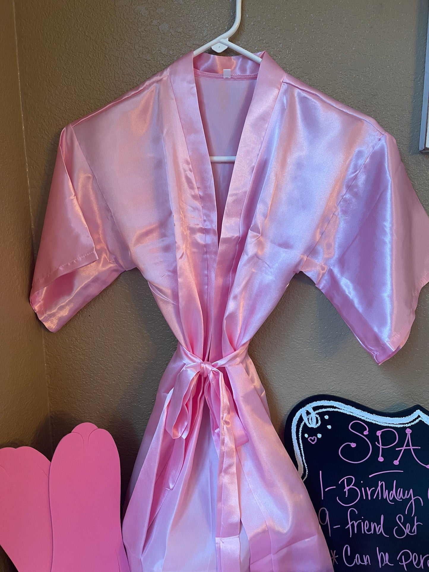 Pink satin spa robe with V-neck, wide sleeves, and tied waist