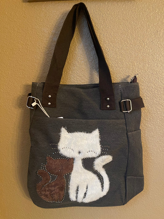 Dark canvas bookbag tote with animal cat applique, brown leather handles, side pockets