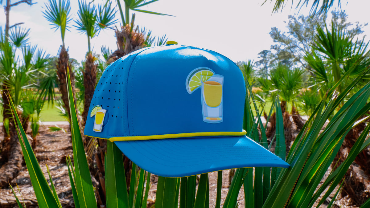 Blue snapback golf cap with yellow brim trim and tequila-lime front ball marker holder.