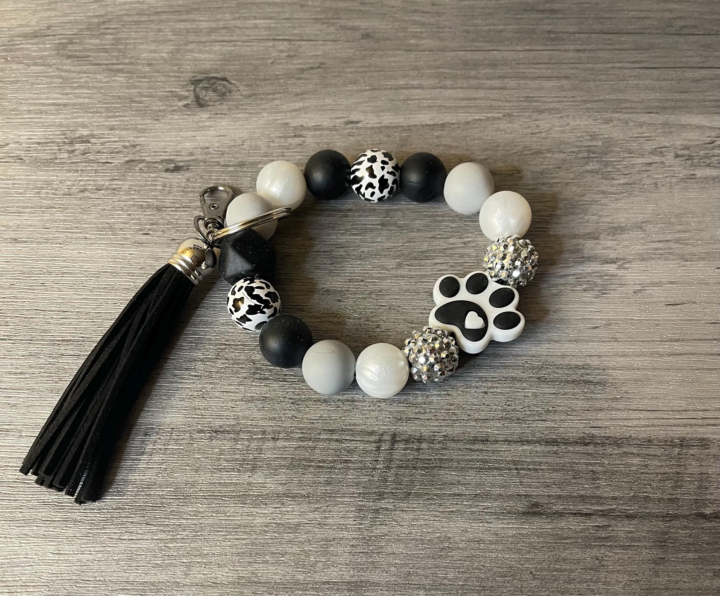 Silicone beaded wristlet with paw charm, black and white beads, black tassel keyring
