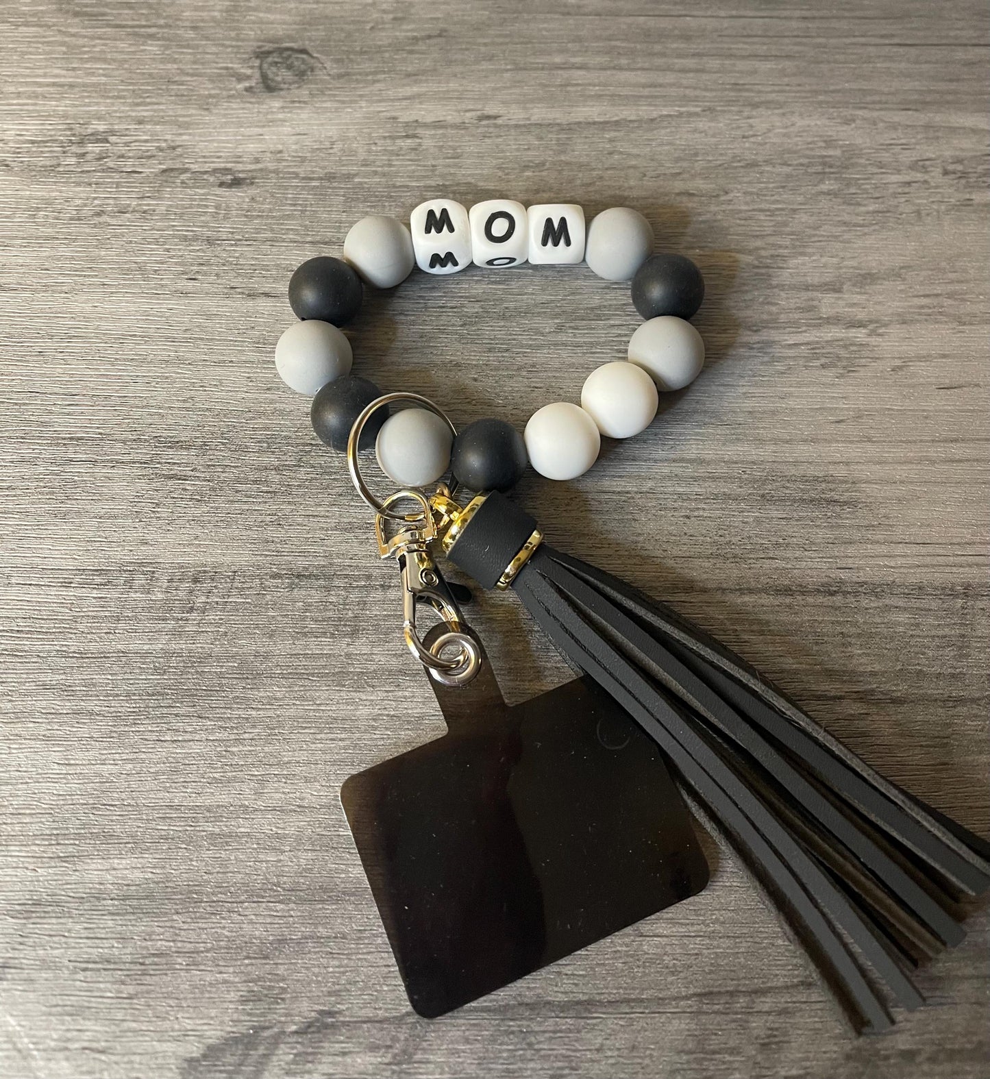 Silicone beaded wristlet with letter beads, mom tag charm, black tassel, keyring, black and cream