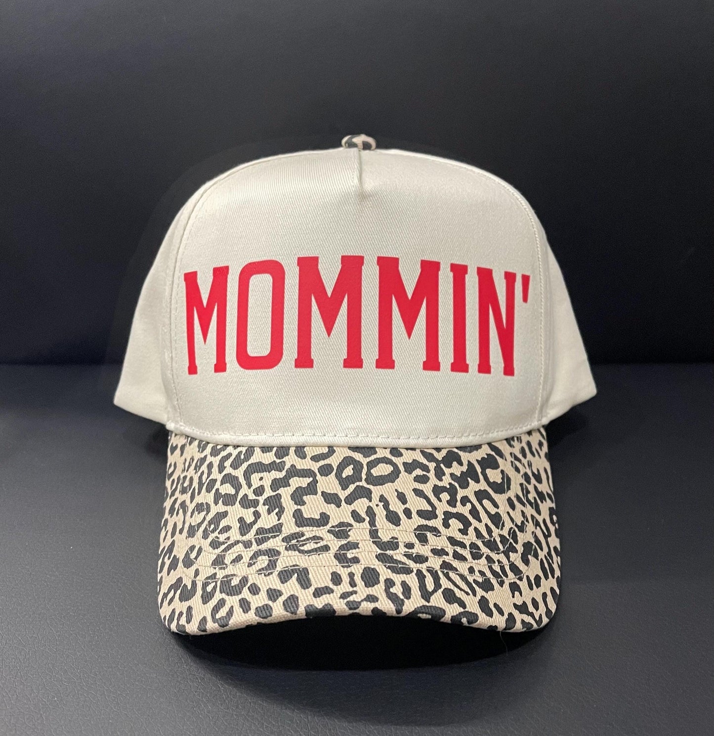Cream trucker hat with red MOMMIN text and leopard-pattern front brim