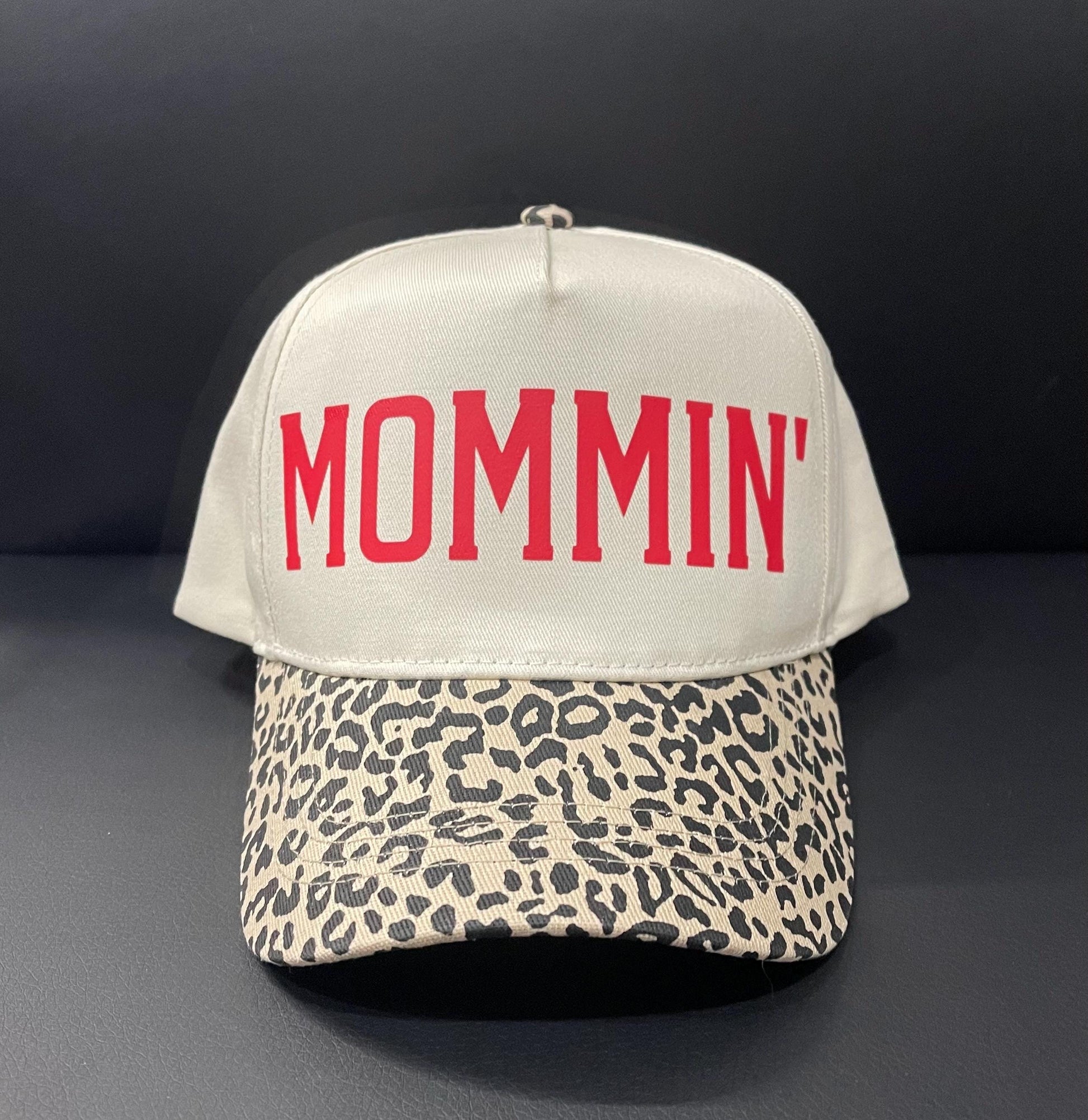 Cream trucker hat with red MOMMIN text and leopard-pattern front brim