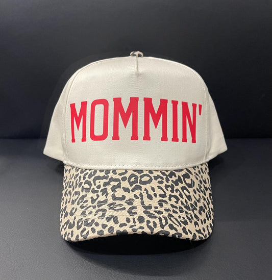 Cream trucker hat with red MOMMIN text and leopard-pattern front brim