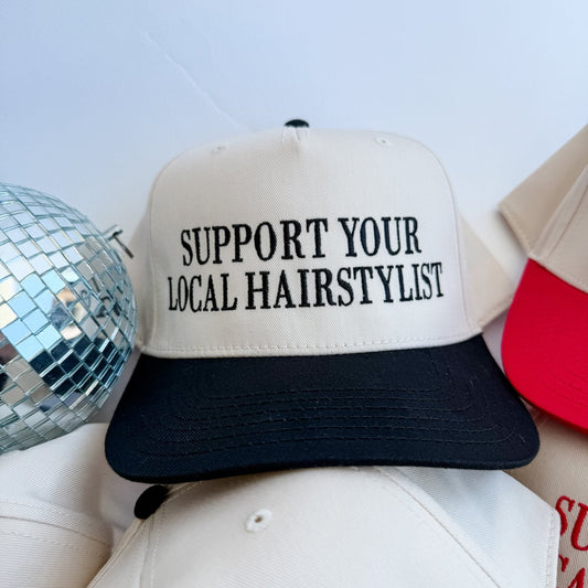 Cream trucker hat with black brim and embroidered 'Support Your Local Hairstylist'