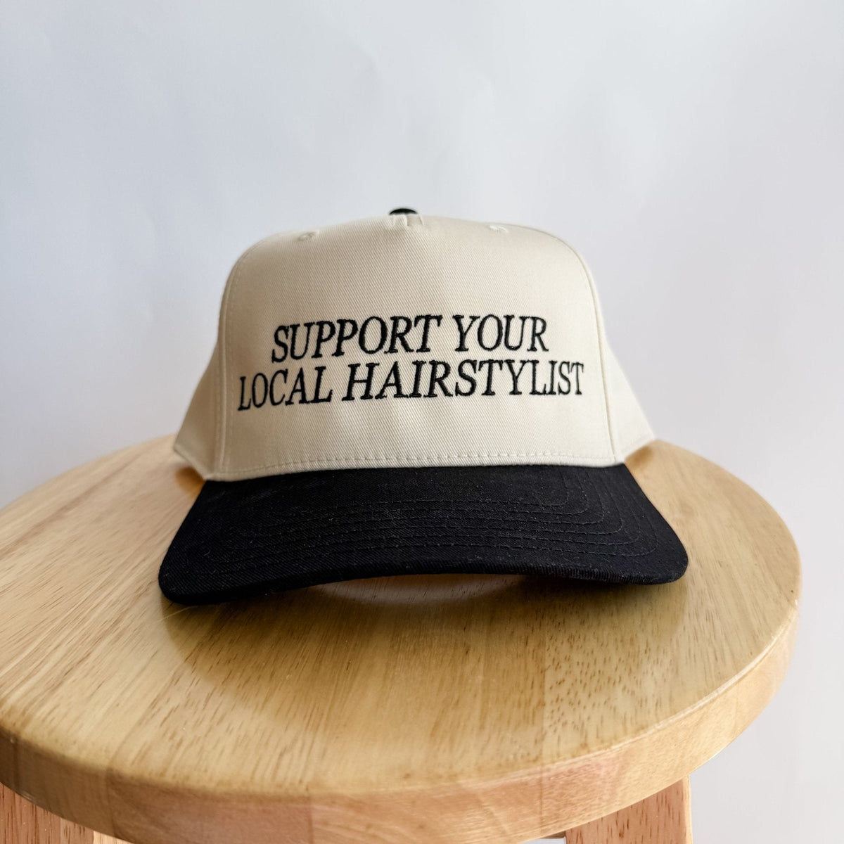 Cream and black trucker hat, front embroidery 'Support Your Local Hairstylist'